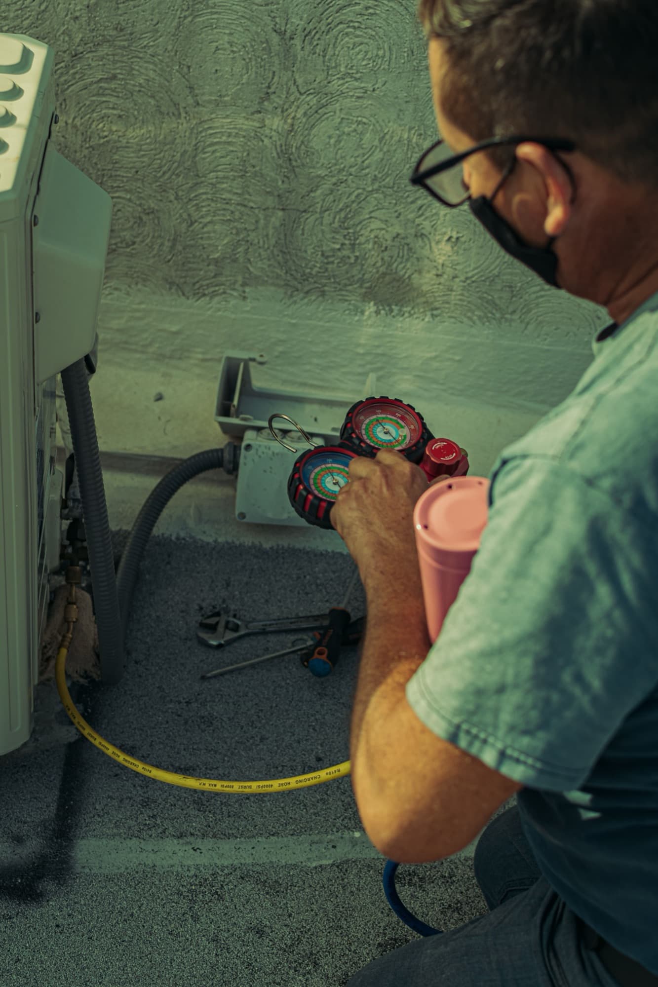 Technician reading manifold gauges during a service call