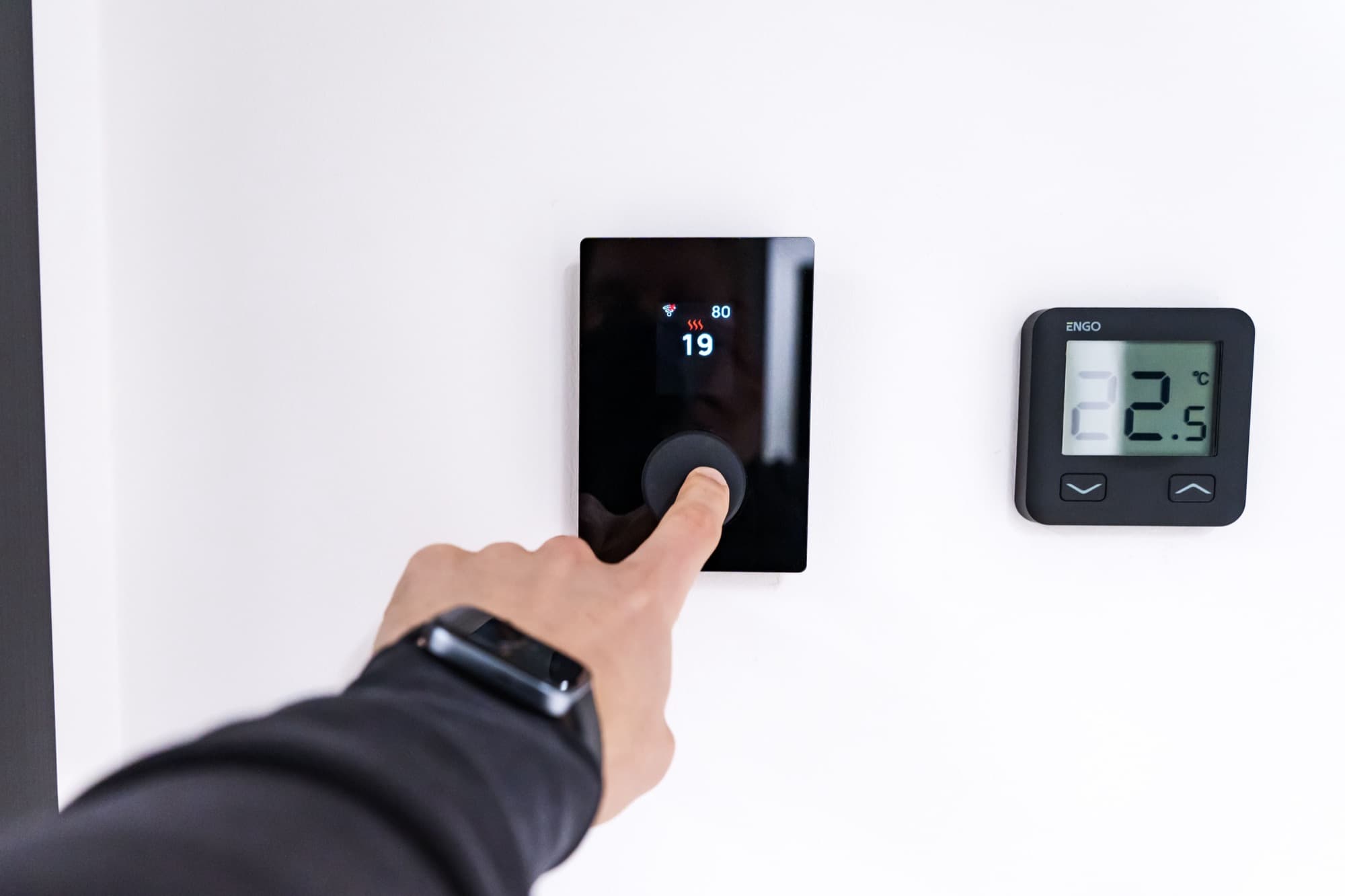 Hand adjusting a home thermostat